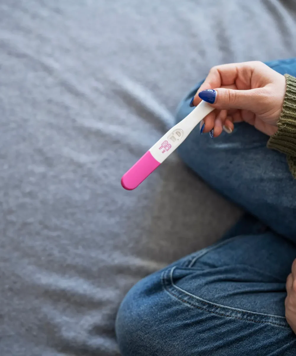 Unrecognisable woman holding positive pregnancy test.